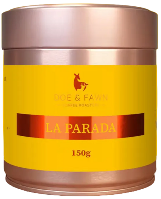 A 150g canister of Rode & Fawn Coffee Roasting 'La Parada' coffee, featuring a bright yellow label and metallic rose gold lid and base, set against a yellow circular graphic on a white background.